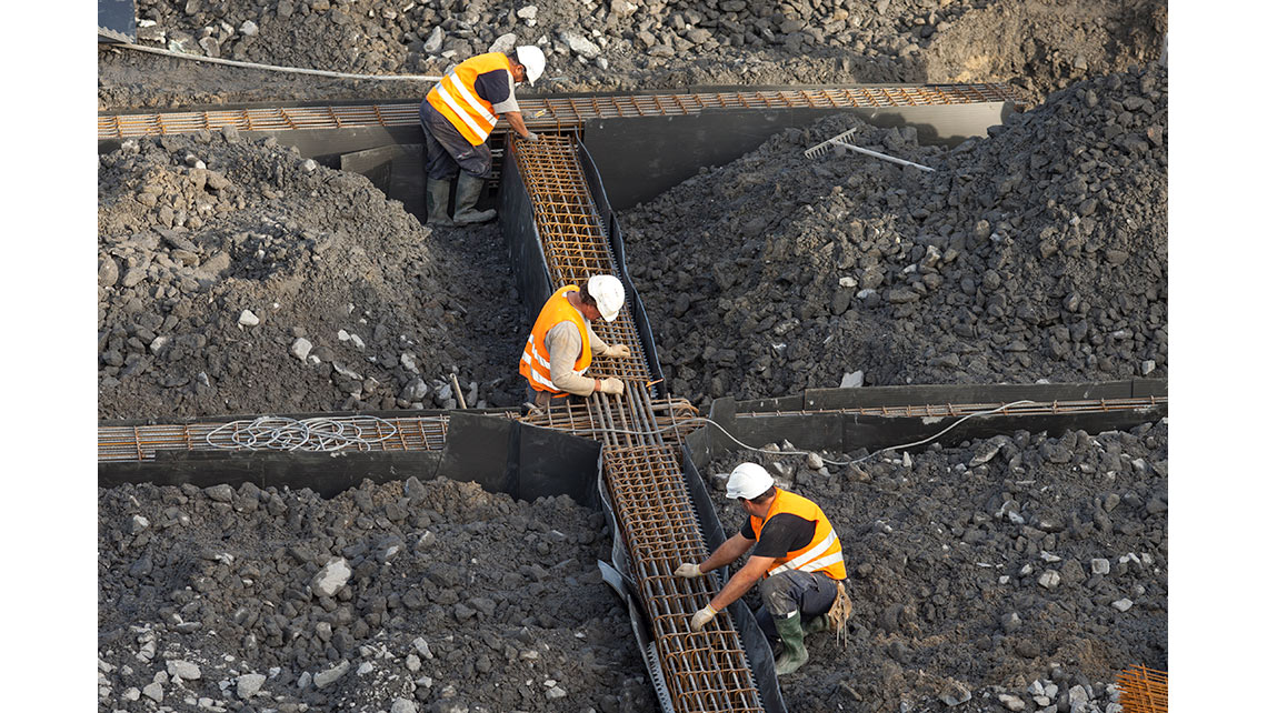 Sur le chantier du magasin IKEA de Bayonne, trois ouvriers réalisent les fondations ; © Richard Nourry