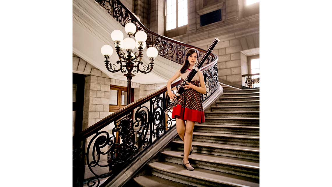 Portrait de Clara, élève au Conservatoire de Bordeaux,  jouant du basson tout en descendant un escalier magistral. © Richard Nourry