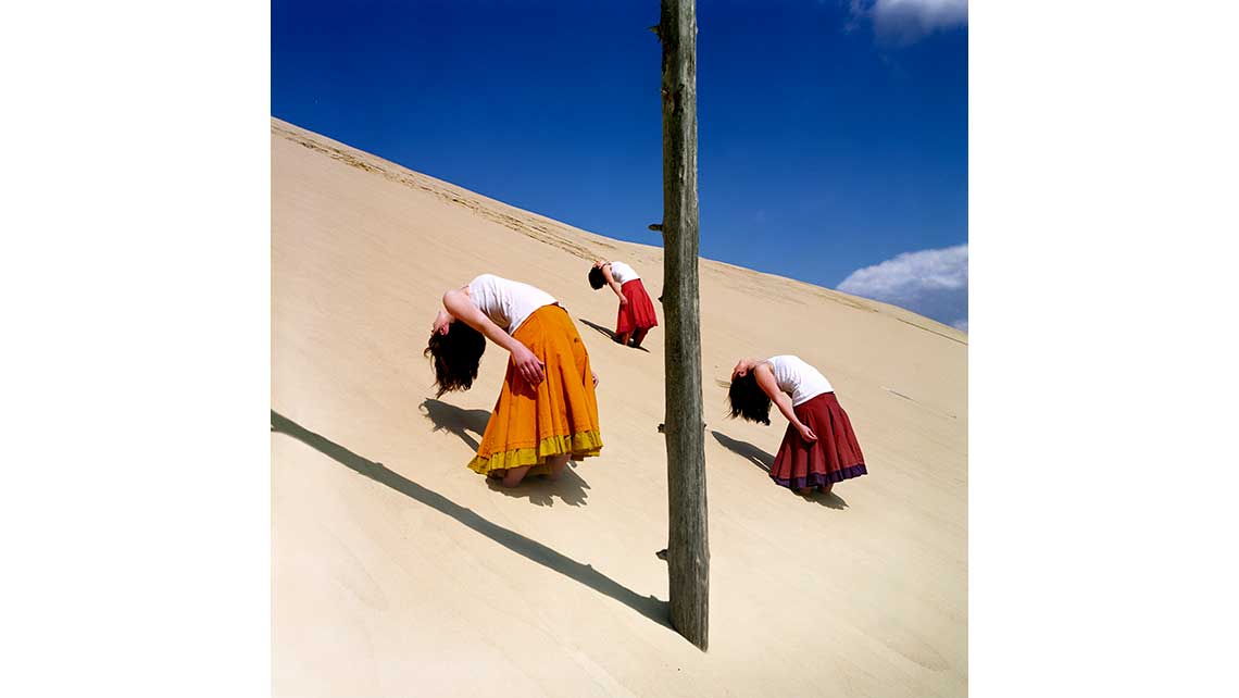 3 danseuses du Conservatoire de Bordeaux photographiées au flan d'une dune. © Richard Nourry