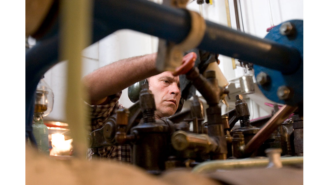 Mécanicien travaillant dans la salle des machines sur le moteur du bateau des phares et balises ‘Roi Gradlon’ ; © Richard Nourry