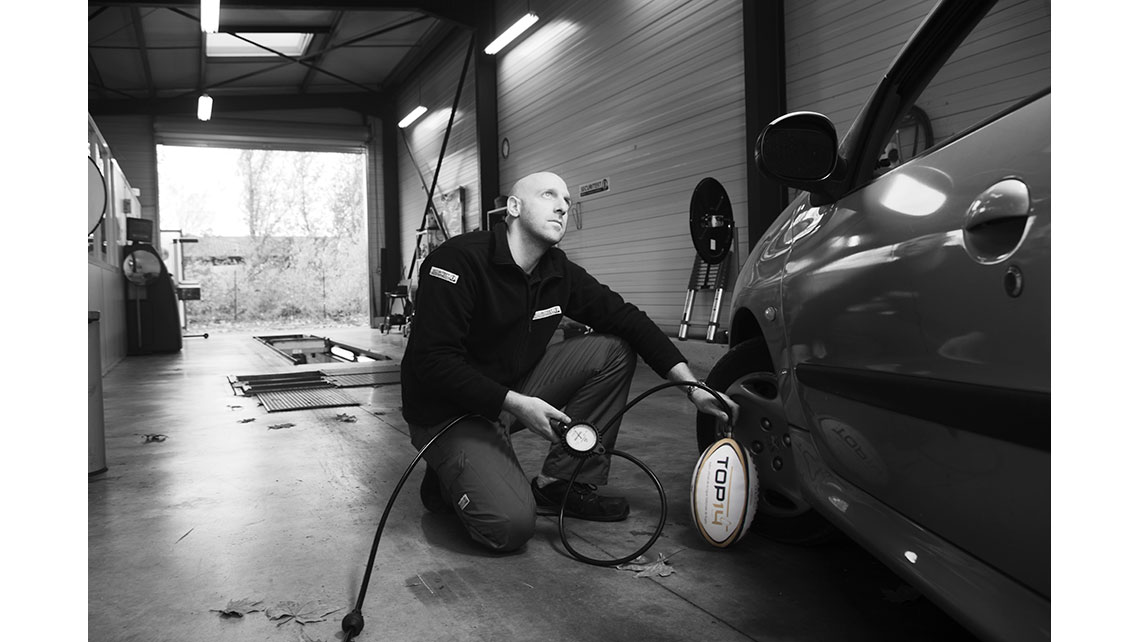 Portrait d'un mécanicien gonflant un ballon de rugby, © Richard Nourry