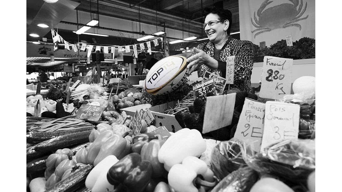 Portrait d'une vendeuse au marché tenant un ballon de rugby, © Richard Nourry