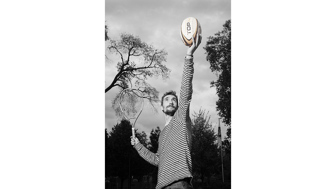 Portrait d'un tennisman en train de servir avec un ballon de rugby au lieu de la balle de tennis, © Richard Nourry